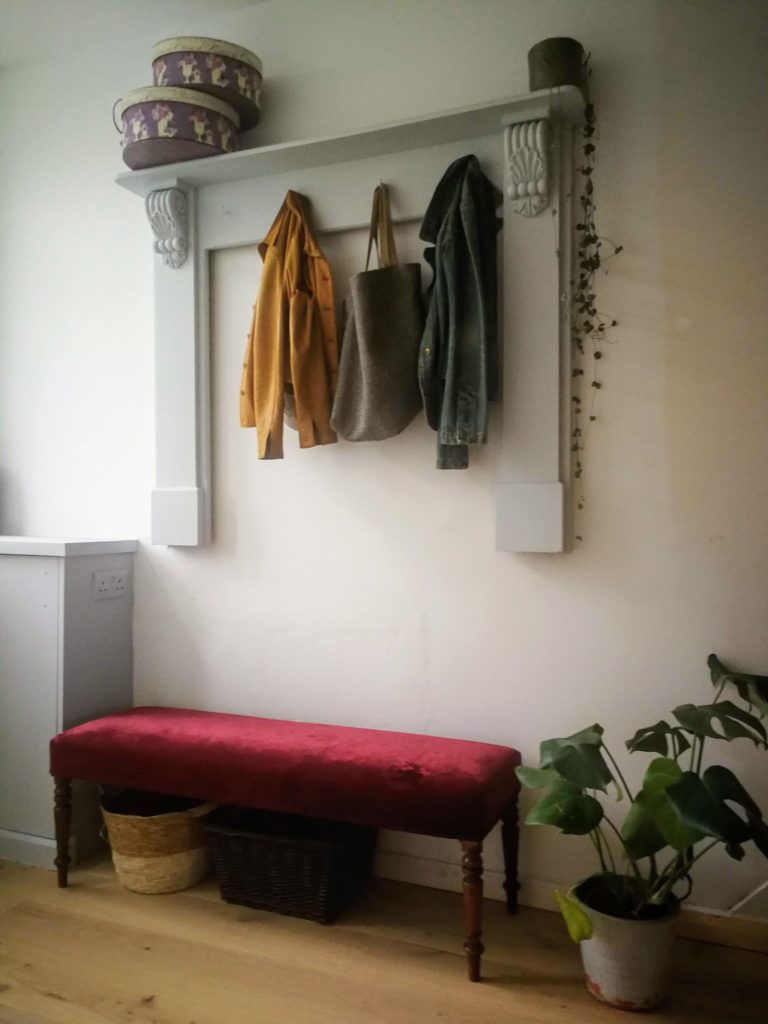 Contemporary hallway makeover in frenck grey with upcycled mantlepiece and red velvet second hand bench