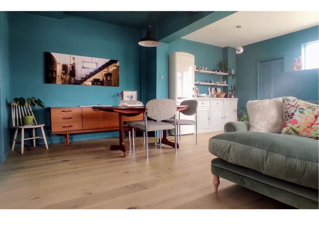 Contemporary living room remodel. Open plan kitchen and living room with monochrome teal walls and vintage G-Plan side board